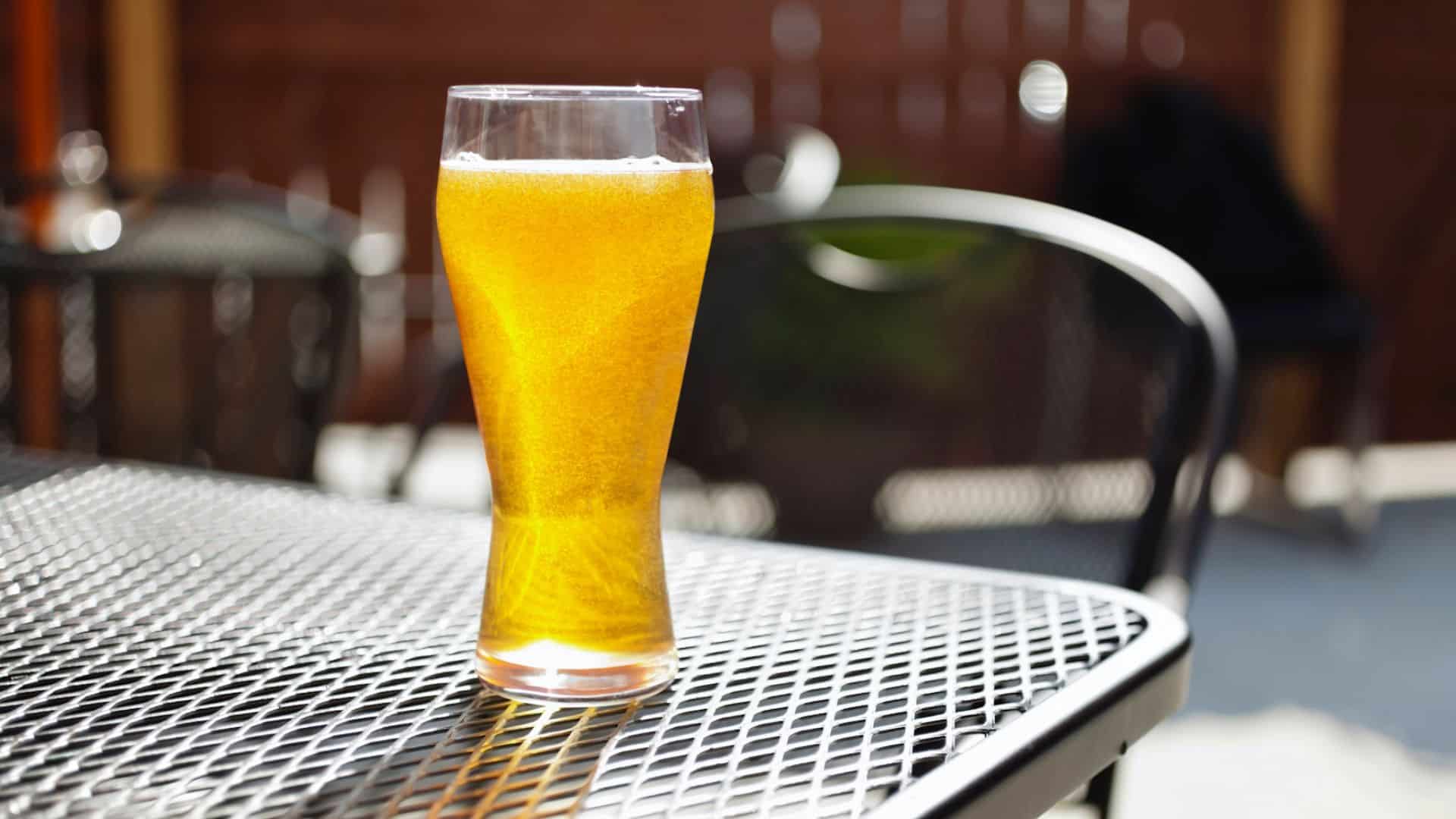 a pint of beer sits on a table on an outdoor patio