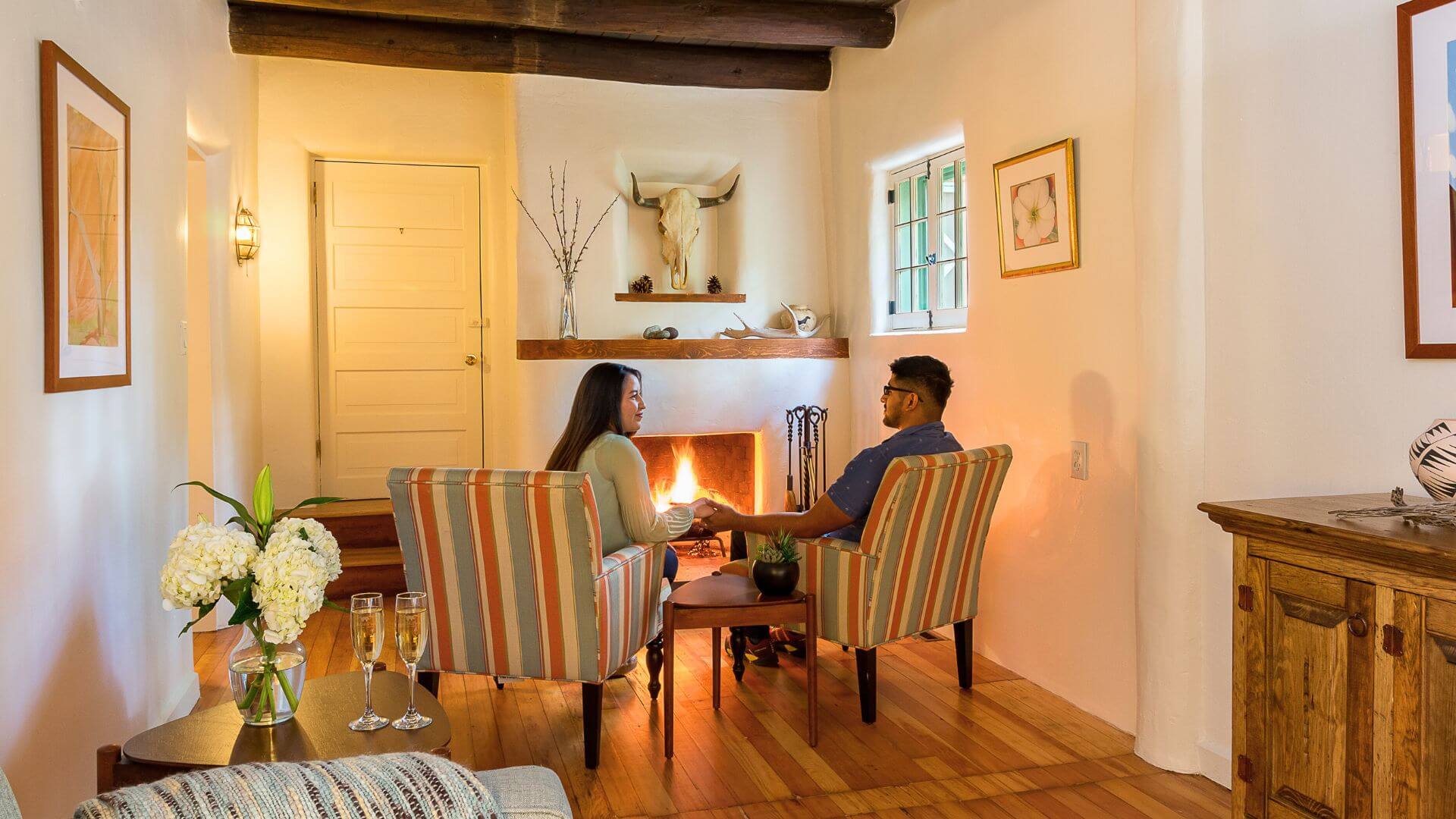 back view of couple holding hands in front of fireplace at inn of the turquoise bear