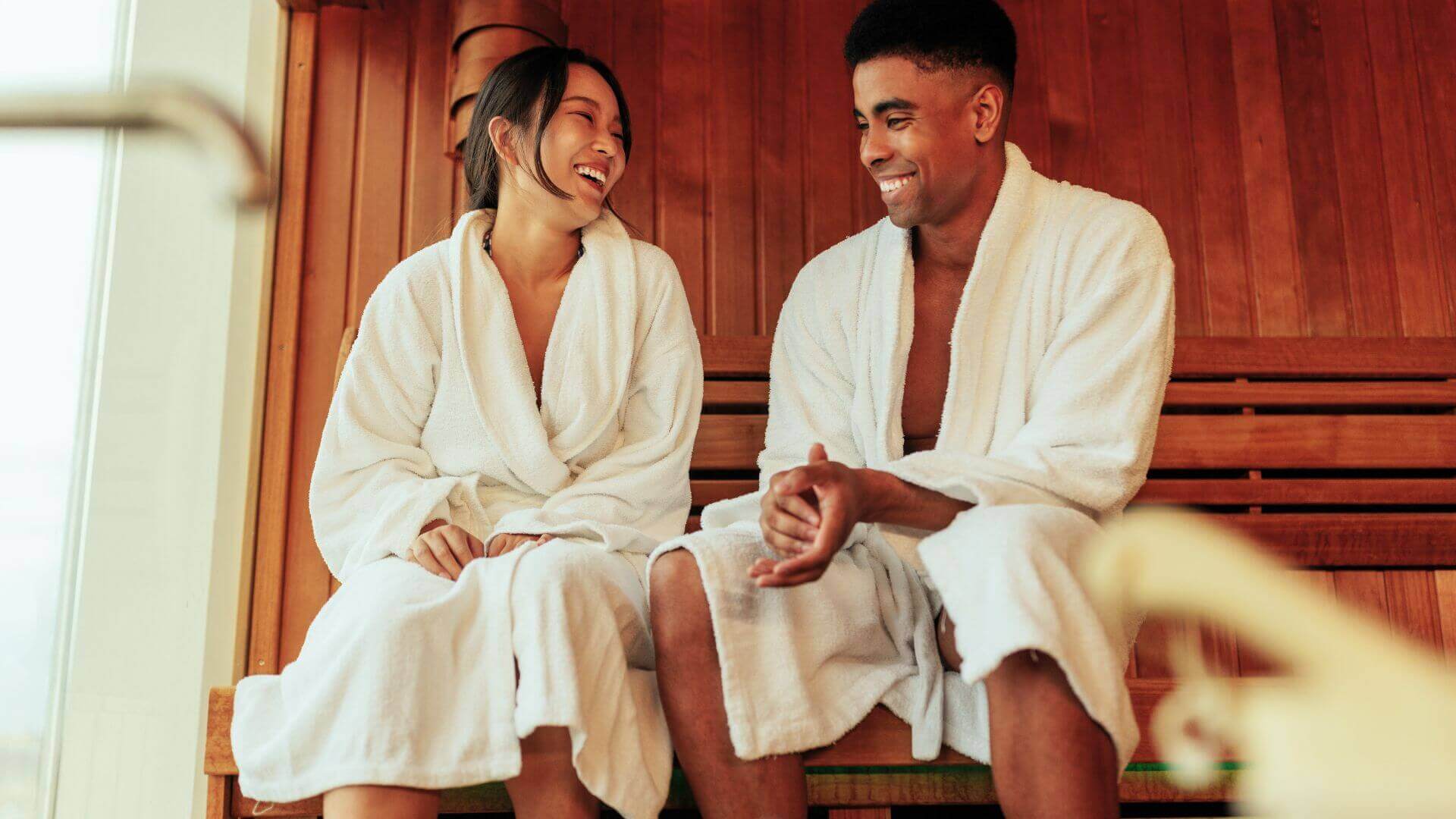 couple laughing and relaxing in sauna