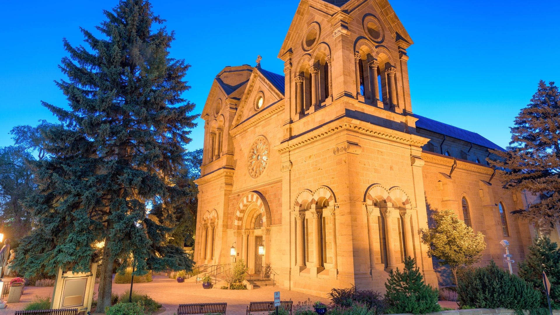 cathedral basilica of st. francis of assisi in santa fe with the lights shining on it at dusk