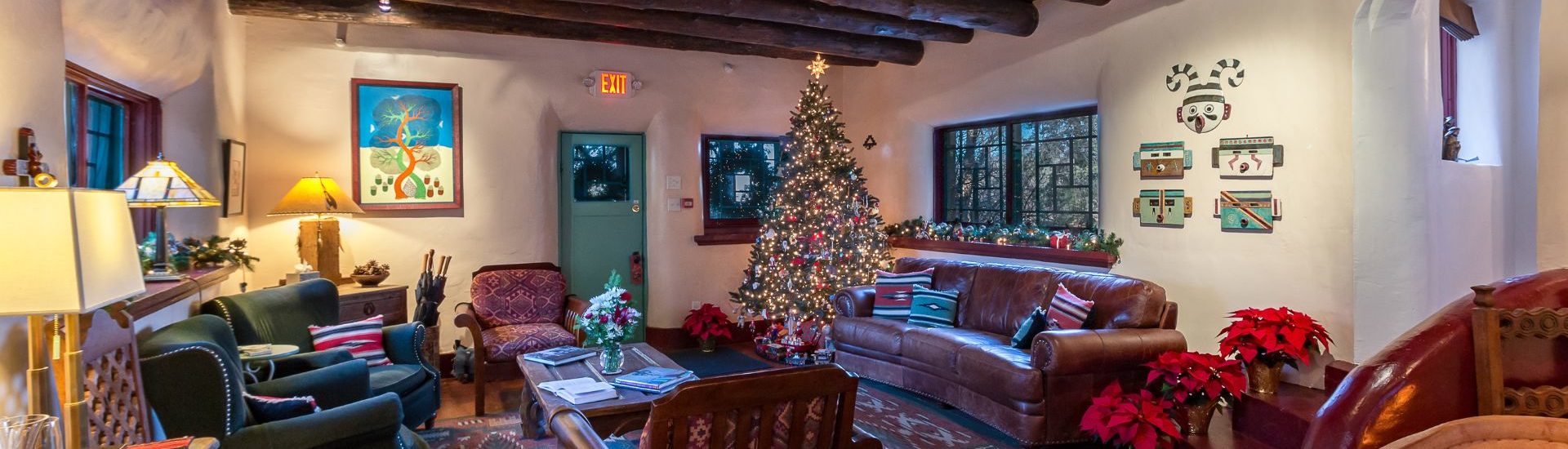 Common living area at The Bear with wood floors and beams all decorated for the holidays with a lit Christmas tree in the corner